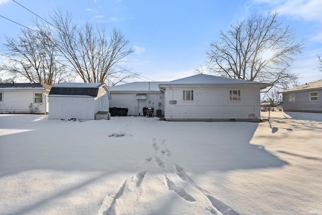 snow covered property with a shed