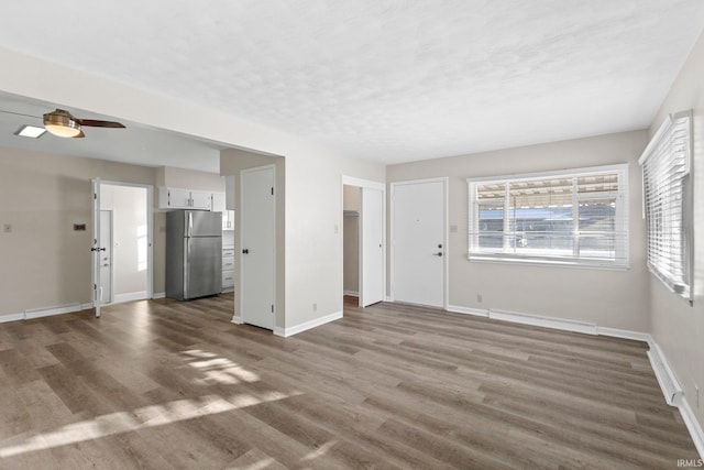 unfurnished living room featuring hardwood / wood-style floors and ceiling fan