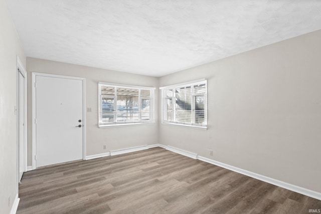 spare room featuring hardwood / wood-style floors and a textured ceiling