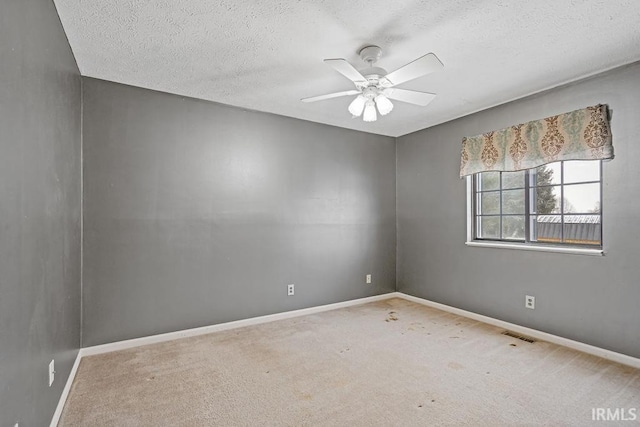 carpeted empty room with a textured ceiling and ceiling fan