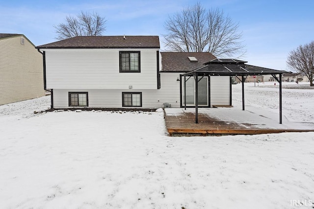 snow covered back of property with a gazebo