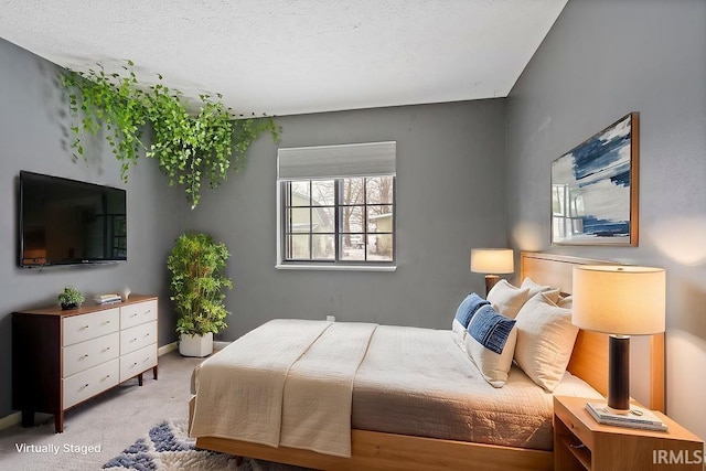 bedroom with light carpet and a textured ceiling