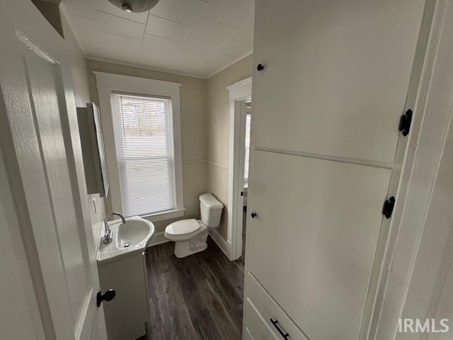 bathroom with wood-type flooring, toilet, vanity, and ornamental molding