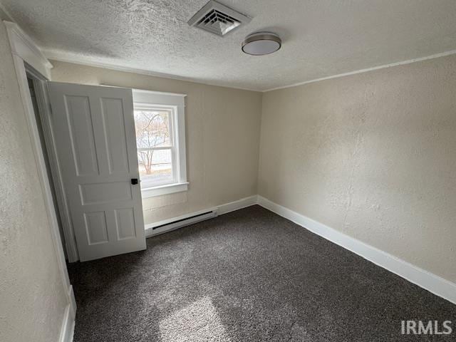 carpeted spare room featuring baseboard heating and a textured ceiling