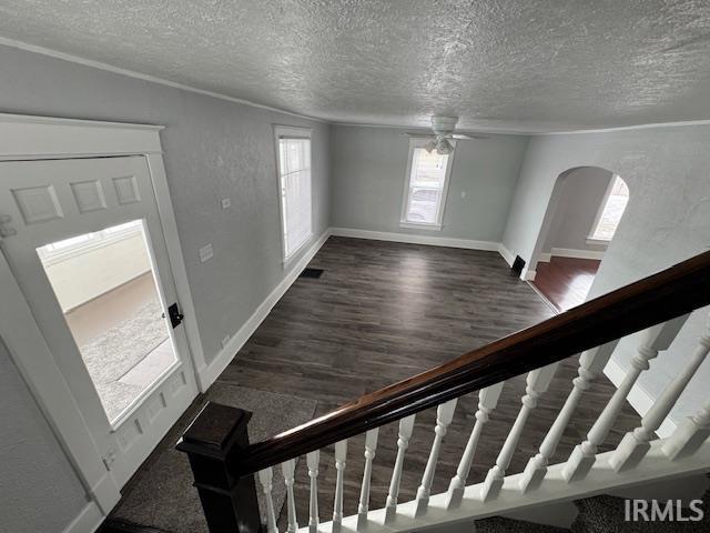 foyer with ceiling fan, a textured ceiling, and dark hardwood / wood-style flooring