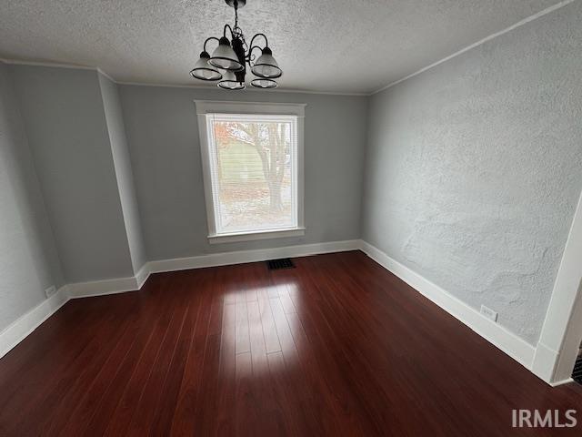 unfurnished dining area featuring a notable chandelier, crown molding, and dark hardwood / wood-style flooring