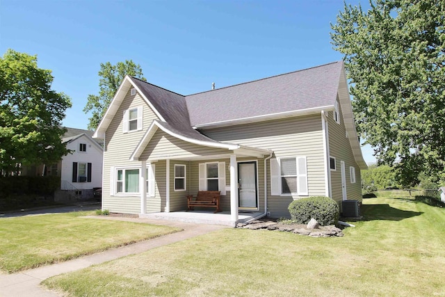 view of front of house featuring a patio area, cooling unit, and a front lawn