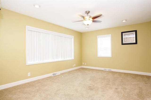 carpeted spare room featuring ceiling fan