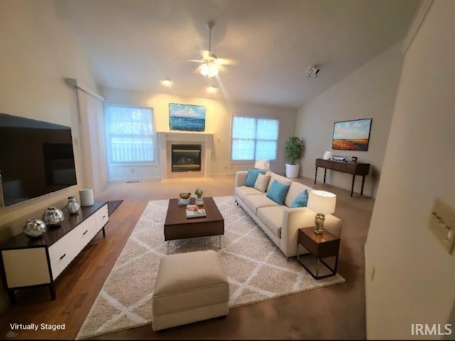 living room featuring ceiling fan, wood-type flooring, a healthy amount of sunlight, and vaulted ceiling