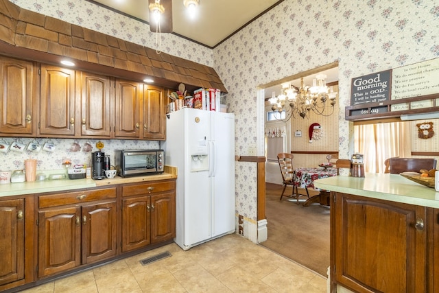 kitchen with decorative light fixtures, white fridge with ice dispenser, and light carpet