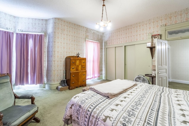 bedroom featuring carpet floors, a closet, and a chandelier