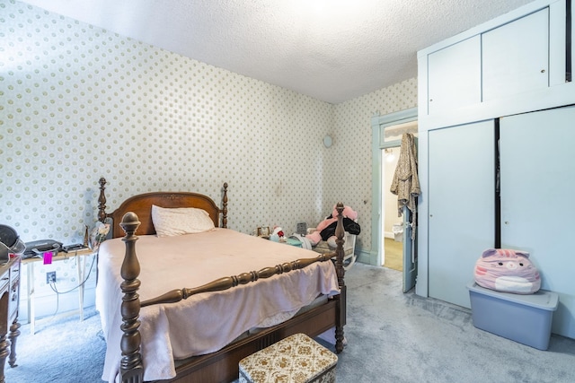 carpeted bedroom featuring a textured ceiling and a closet