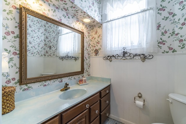 bathroom with plenty of natural light, toilet, and vanity