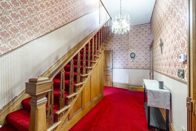 staircase featuring a notable chandelier