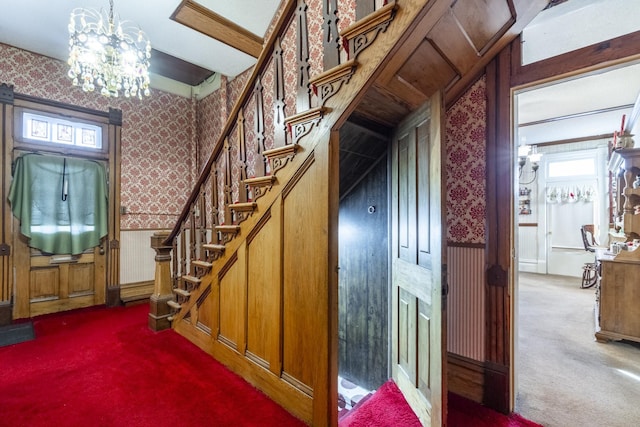 staircase with carpet and an inviting chandelier