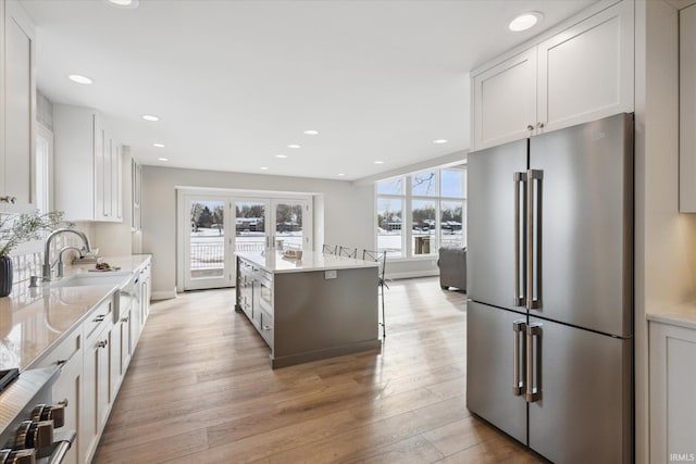 kitchen with sink, white cabinets, and high end fridge