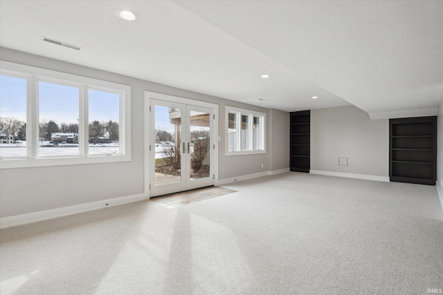 interior space featuring light carpet, plenty of natural light, and french doors