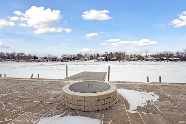 snow covered patio featuring an outdoor fire pit