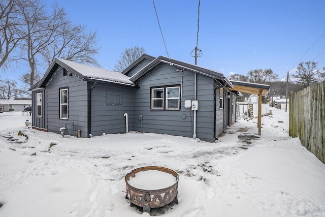 snow covered house featuring an outdoor fire pit