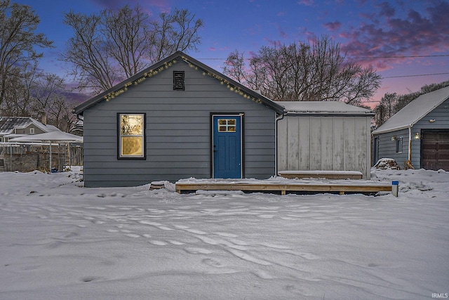 view of snow covered back of property