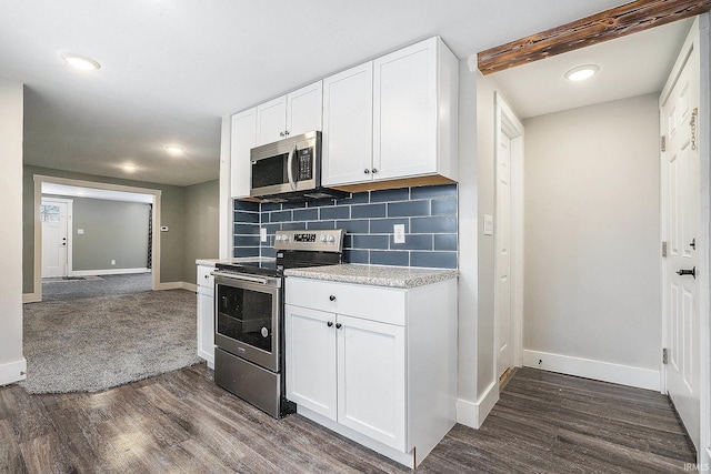 kitchen featuring dark hardwood / wood-style flooring, appliances with stainless steel finishes, white cabinets, beam ceiling, and decorative backsplash