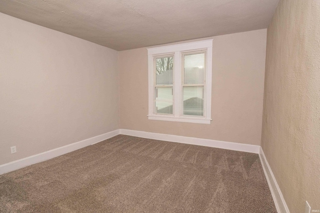 carpeted empty room with a textured ceiling