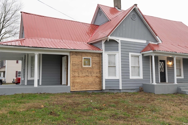 back of house featuring a lawn and a porch