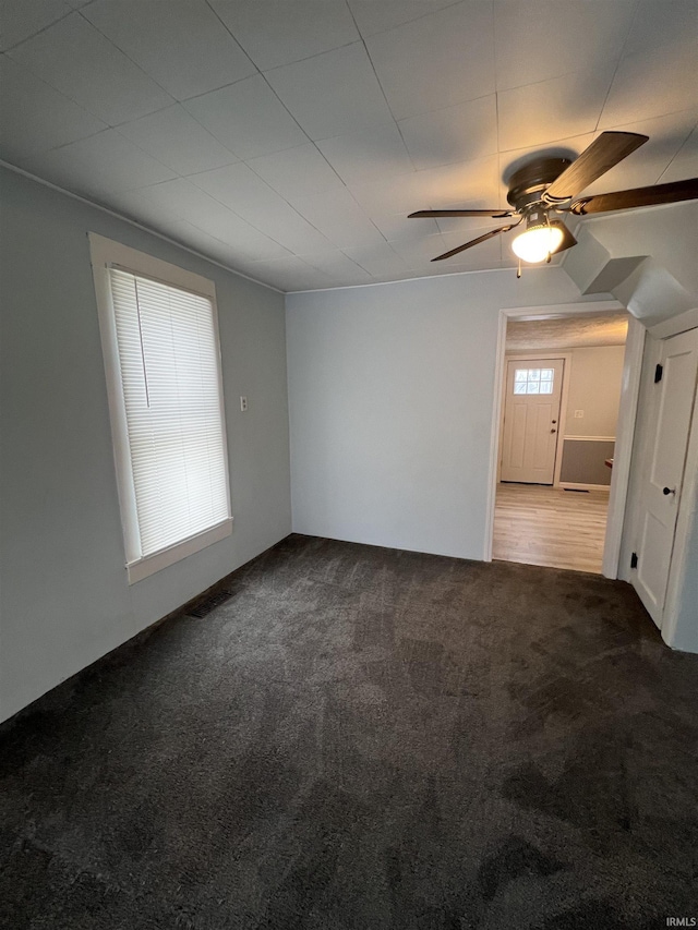 unfurnished room featuring ceiling fan and carpet floors