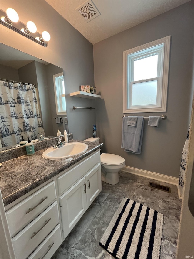 bathroom with a textured ceiling, toilet, and vanity