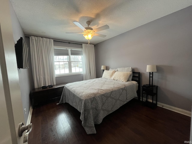 bedroom with ceiling fan, a textured ceiling, and dark hardwood / wood-style flooring