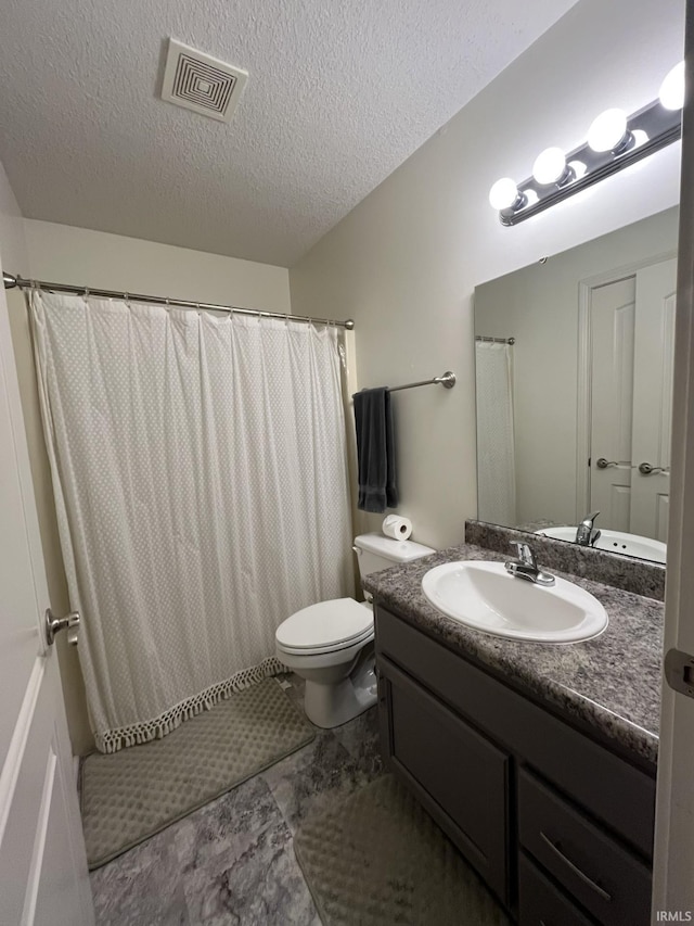 bathroom featuring toilet, a textured ceiling, and vanity