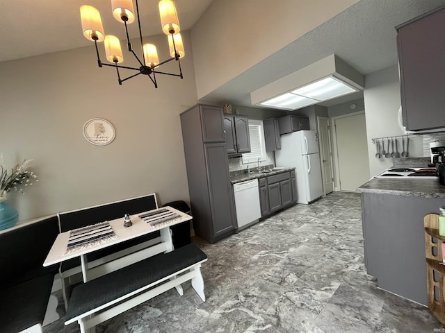 kitchen with pendant lighting, sink, gray cabinetry, white appliances, and a chandelier