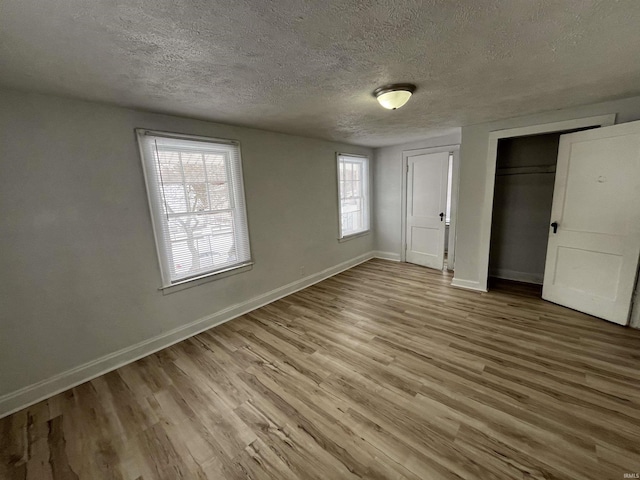 unfurnished bedroom with light wood-type flooring and a textured ceiling