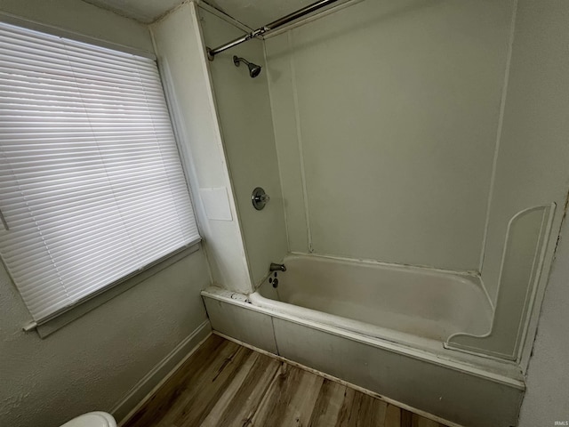 bathroom with hardwood / wood-style flooring and tub / shower combination