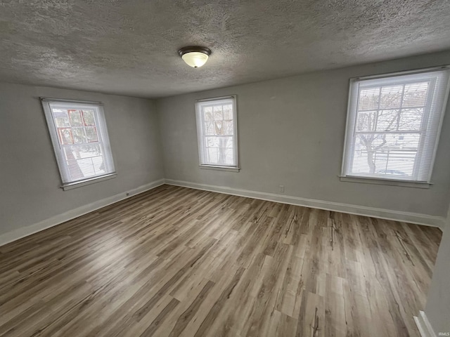 empty room featuring a textured ceiling and light wood-type flooring