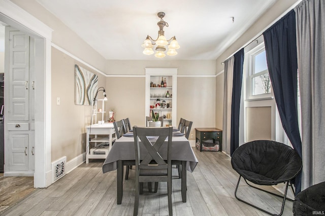 dining area featuring light hardwood / wood-style floors and a notable chandelier