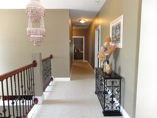 hall featuring carpet floors and a chandelier