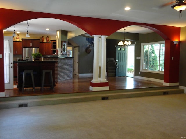 interior space featuring decorative columns and a chandelier