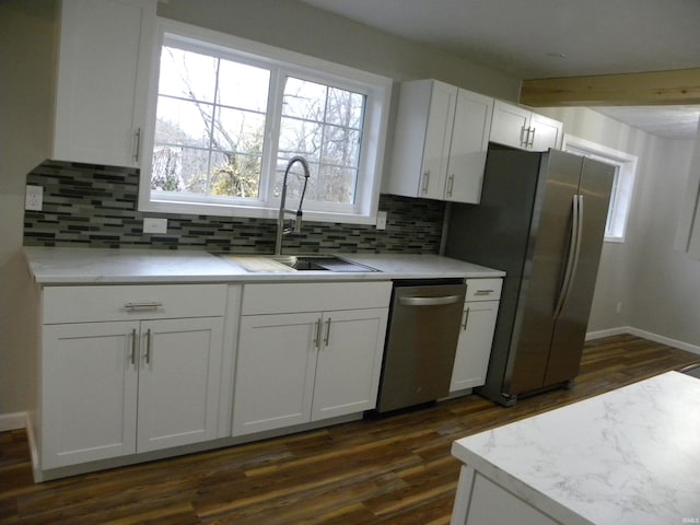 kitchen featuring white cabinets, backsplash, appliances with stainless steel finishes, and sink