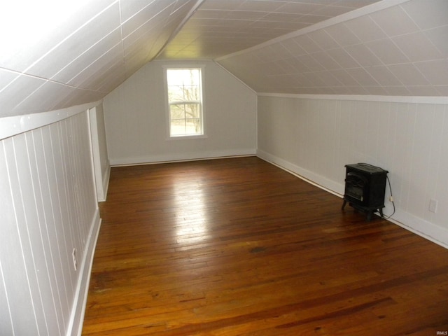 bonus room featuring a wood stove, dark hardwood / wood-style floors, and lofted ceiling