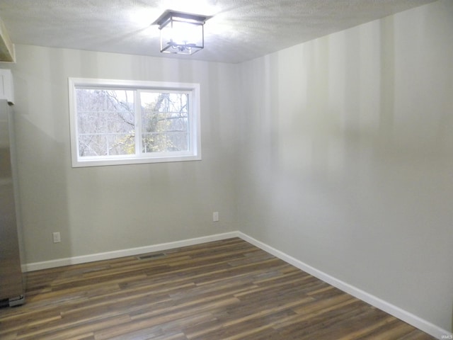 unfurnished room with dark wood-type flooring