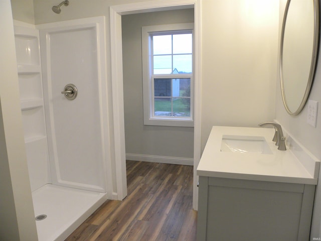 bathroom featuring a shower, hardwood / wood-style floors, and vanity