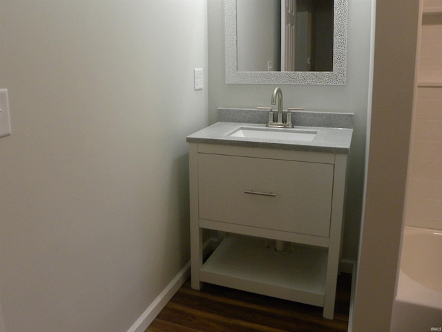 bathroom with sink, hardwood / wood-style flooring, and a washtub