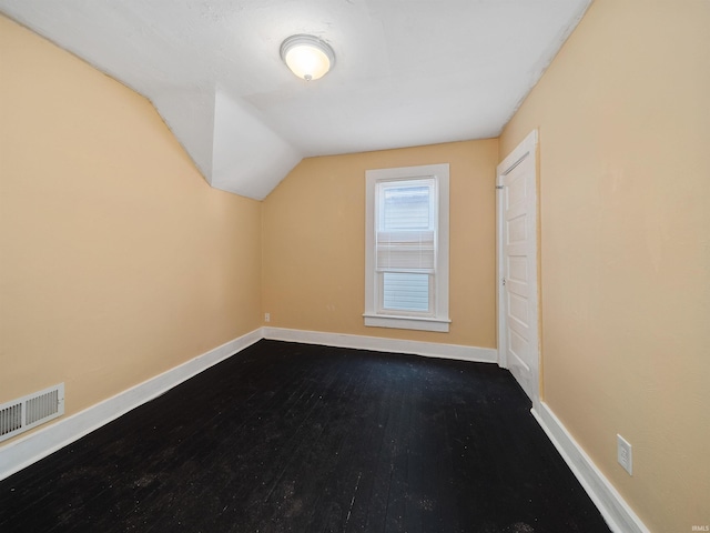 bonus room featuring dark wood-type flooring and lofted ceiling