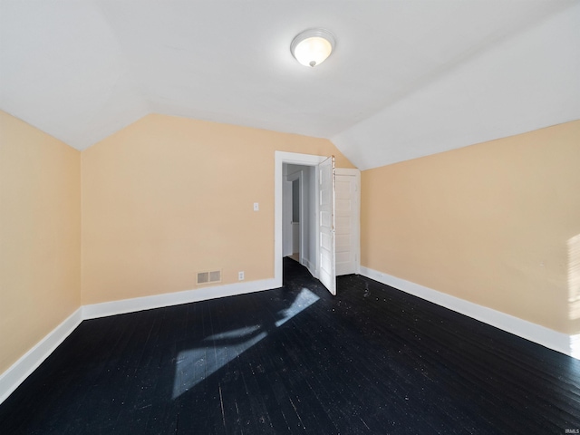 additional living space featuring vaulted ceiling and dark hardwood / wood-style flooring