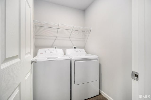 laundry room with dark hardwood / wood-style flooring and washing machine and clothes dryer