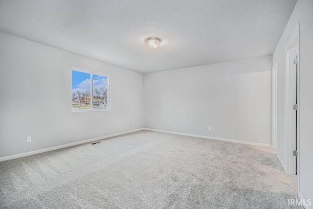 unfurnished room with carpet floors and a textured ceiling