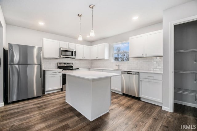 kitchen featuring white cabinetry, hanging light fixtures, sink, dark hardwood / wood-style flooring, and stainless steel appliances