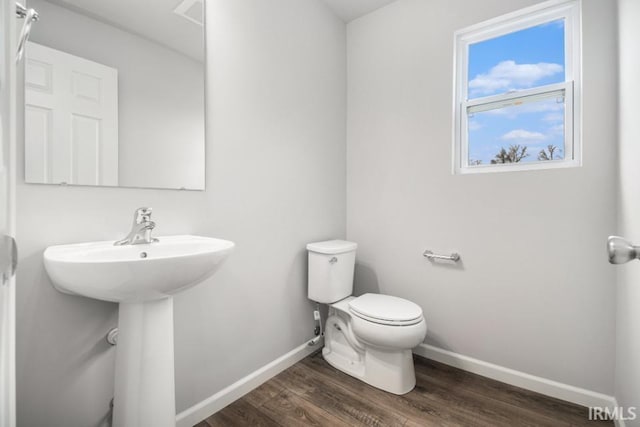 bathroom with hardwood / wood-style floors and toilet