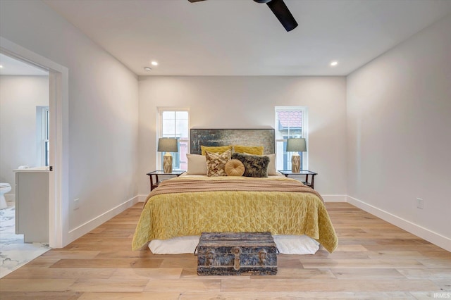 bedroom with ceiling fan, connected bathroom, and light hardwood / wood-style flooring